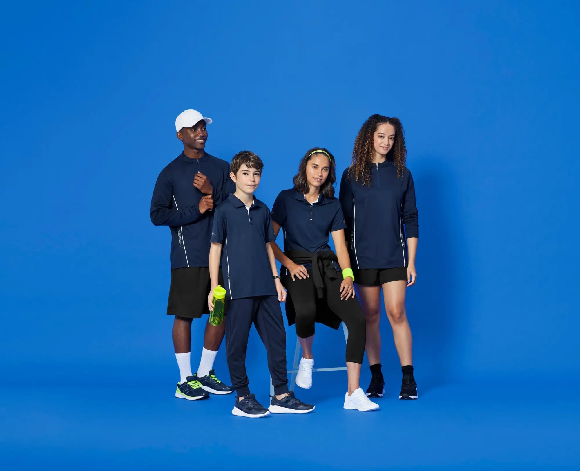 Four people modeling stylish cricket uniforms and sports apparel at Uniform Super Store