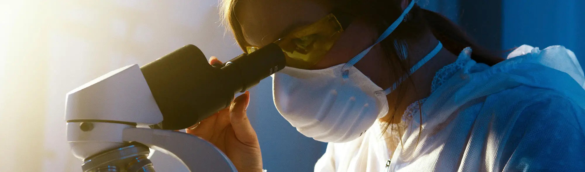 Scientist with microscope using PPE and uniforms in the PPE First Aid Kits collection