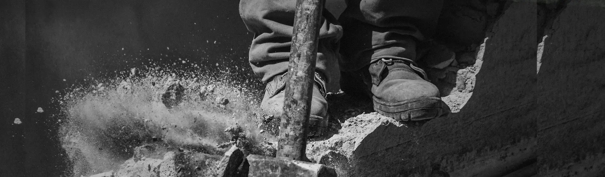 Construction worker using jackhammer in PPE Work Shoes wearing workwear and uniforms