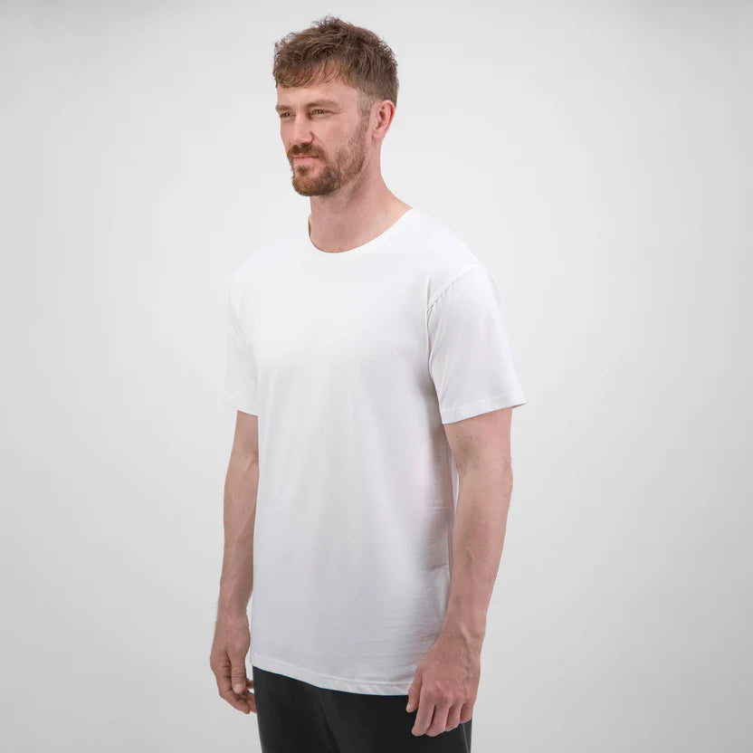 Man wearing a plain white t-shirt against a light gray background