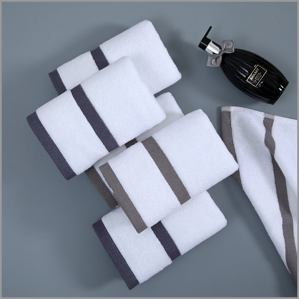 Set of white towels with gray stripes on a gray background