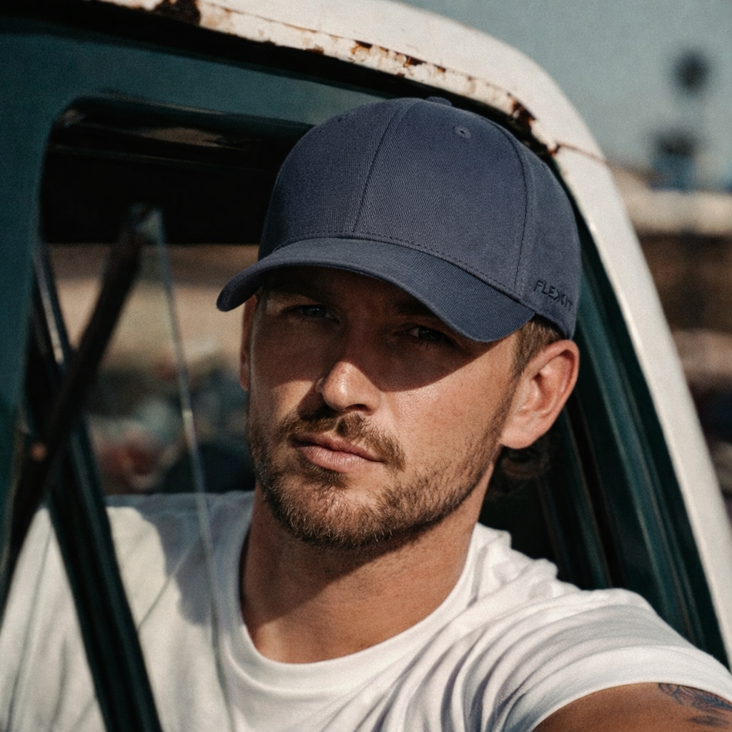 Navy blue flexfit baseball cap with textured fabric and white embroidered logo, perfect for workwear and uniforms