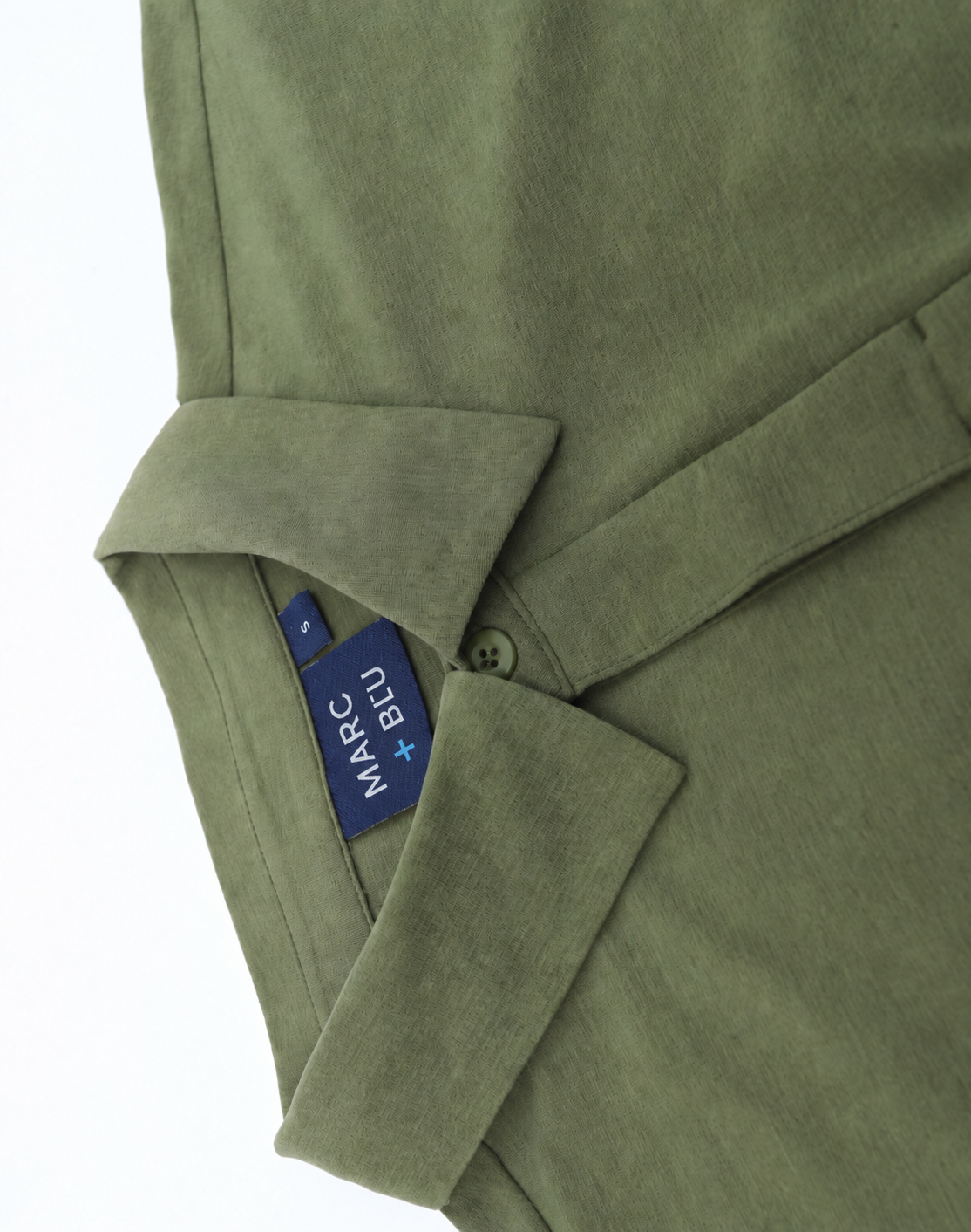 Close-up of an olive green shirt with a collar and a blue Marc + Bleu brand tag visible inside the collar.