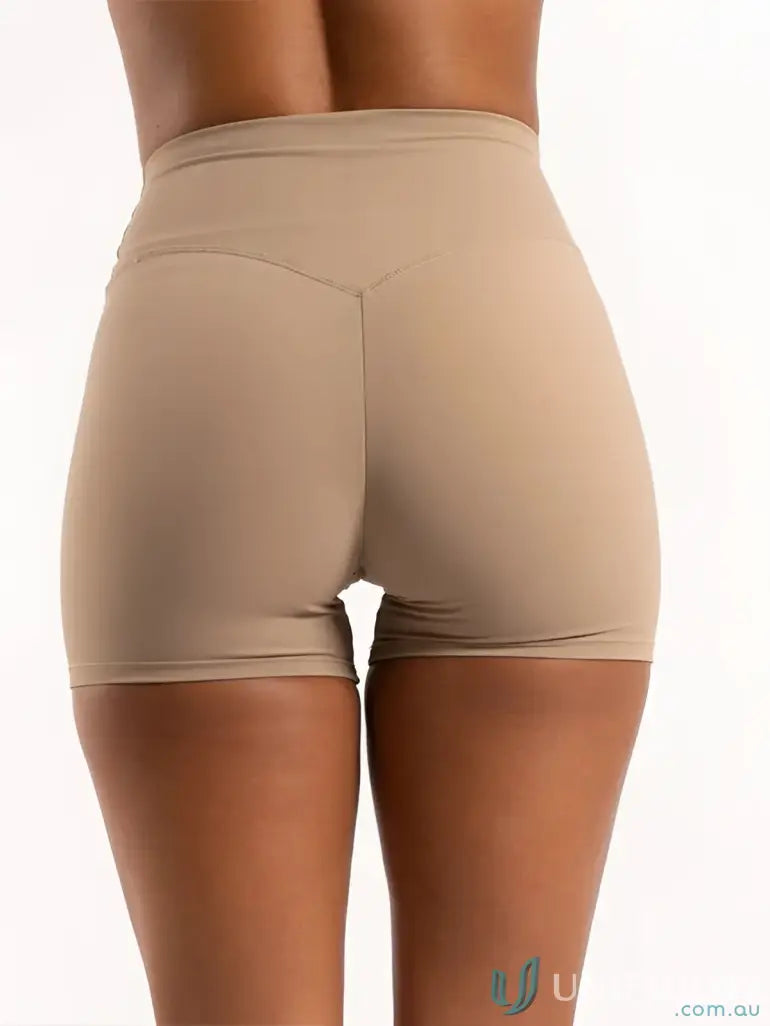 Beige invicible scrunch latte shorts with smooth form-fitting fabric and subtle seams perfect for work uniforms or workwear