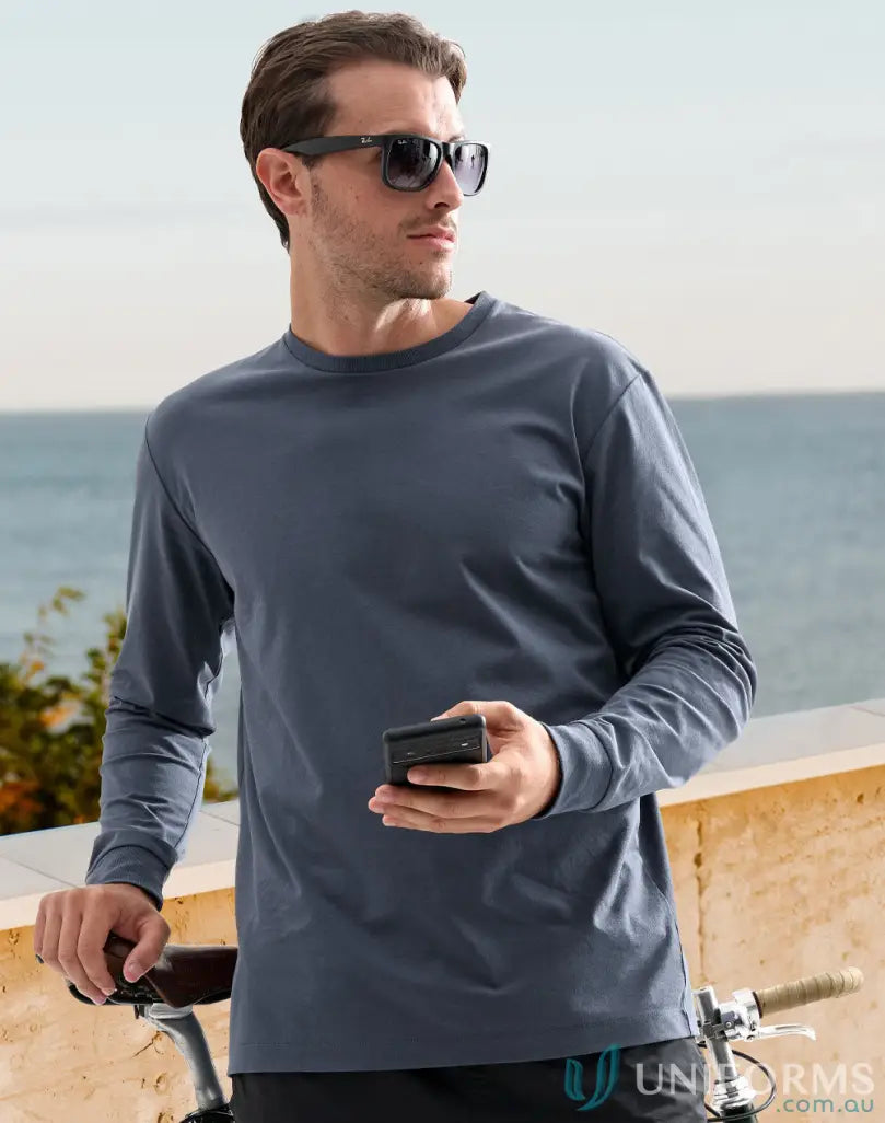 Man in long-sleeved shirt holding a small box showcasing the Mornington LS Tee made of ultimate cotton