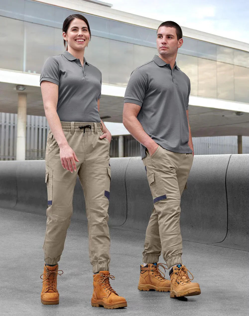 Two folks in gray polo shirts wearing PLANETT unisex cotton stretch cuffed work pants outdoors