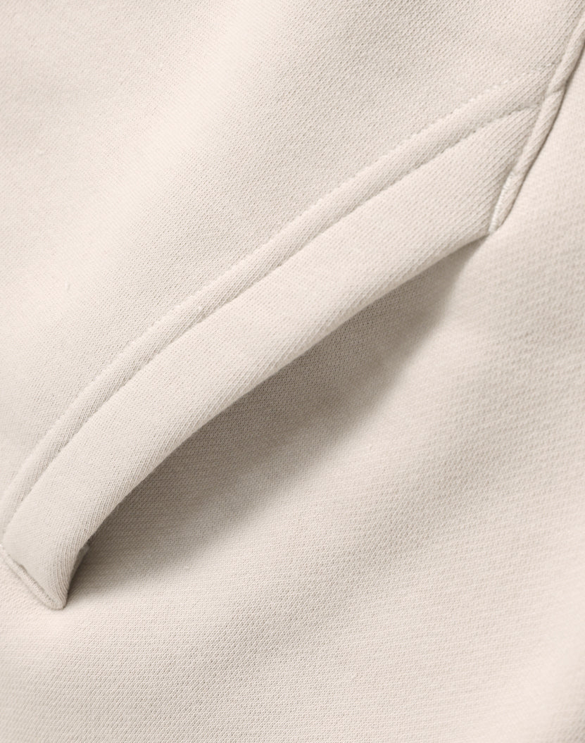 Cream-colored oversized bone hoodie with soft textured fabric and neat seams ideal for workwear and uniforms