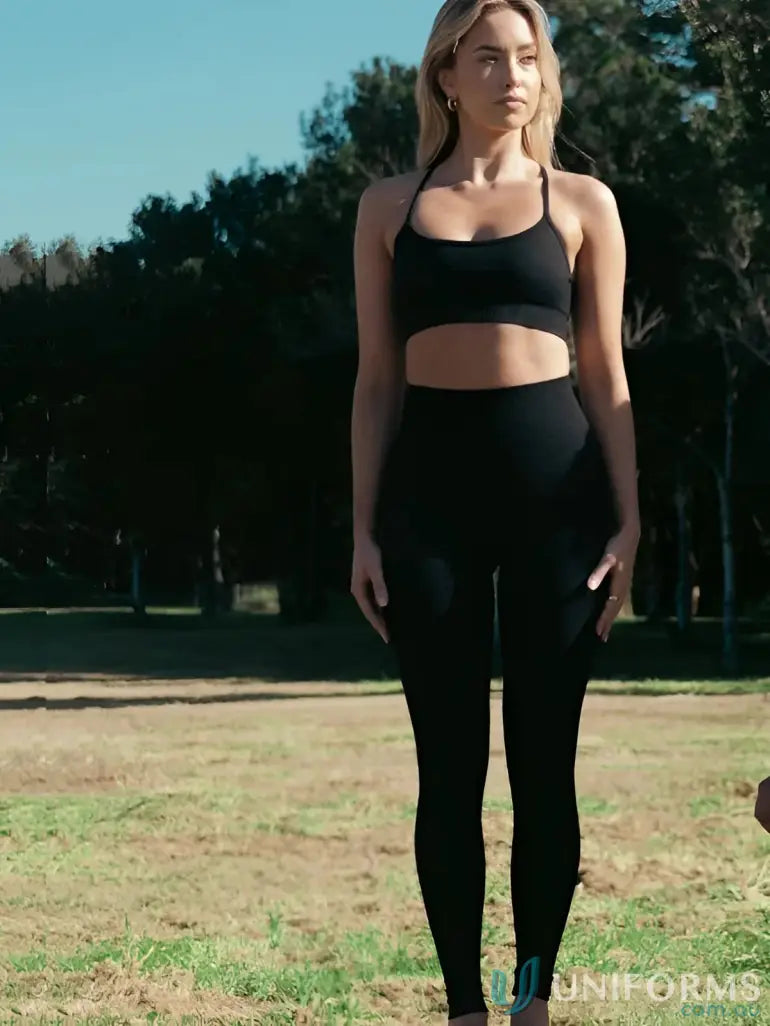 Black athletic crop top with thin straps and seamless invisible scrunch onyx leggings in stretchy fabric perfect for work uniforms