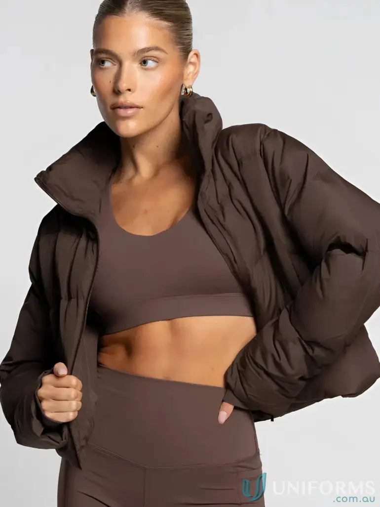 A plush chocolate brown short puffer jacket with high collar and voluminous sleeves perfect for workwear uniforms