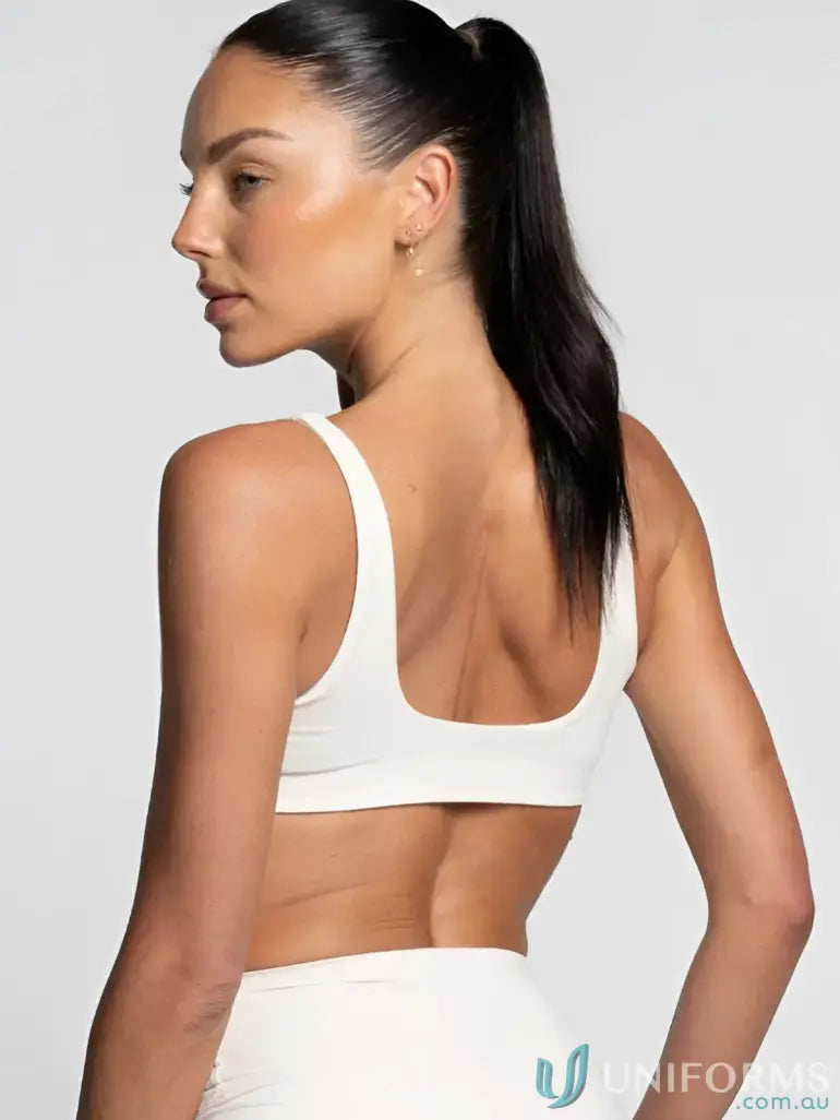 White sports bra with thin straps and rounded back cutout perfect for comfortable work uniforms and active workwear