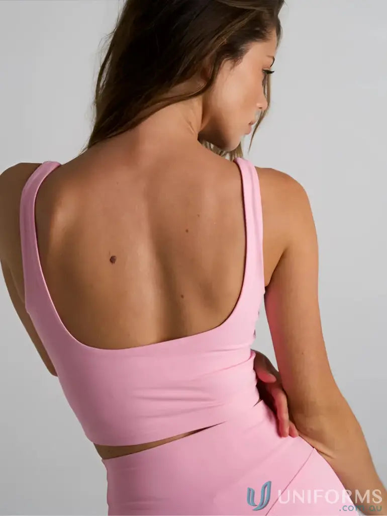 Pink athletic crop top with wide shoulder straps and cutout back perfect for comfy work uniforms or active workwear