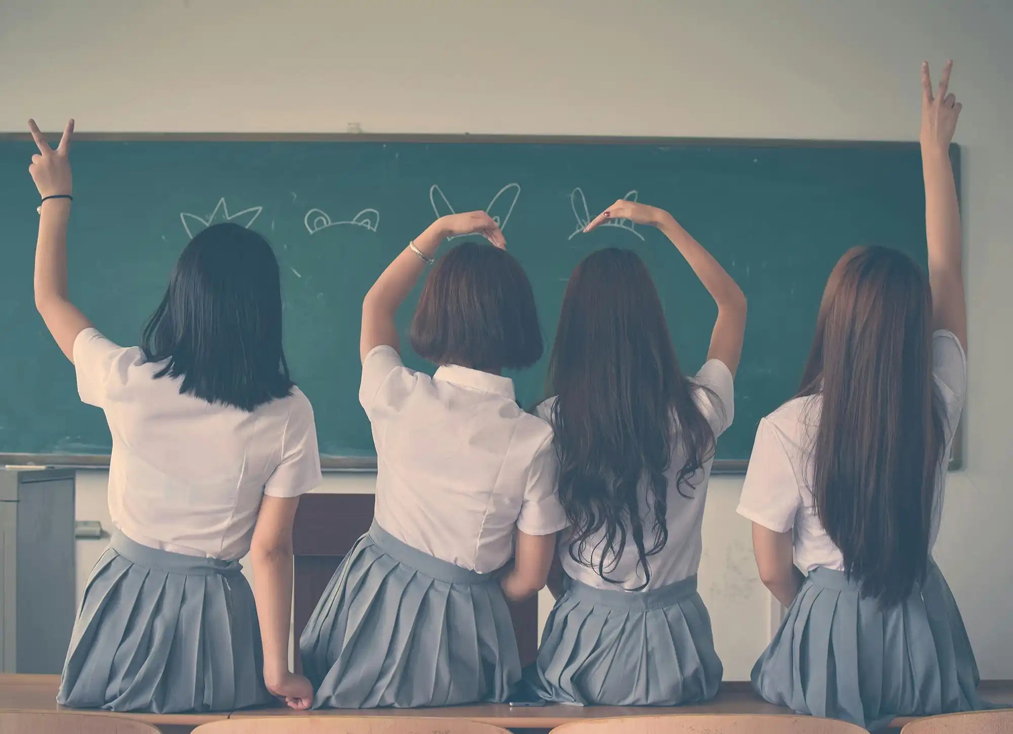 Four female students in school uniforms wearing school jumpers ready to purchase school wear online