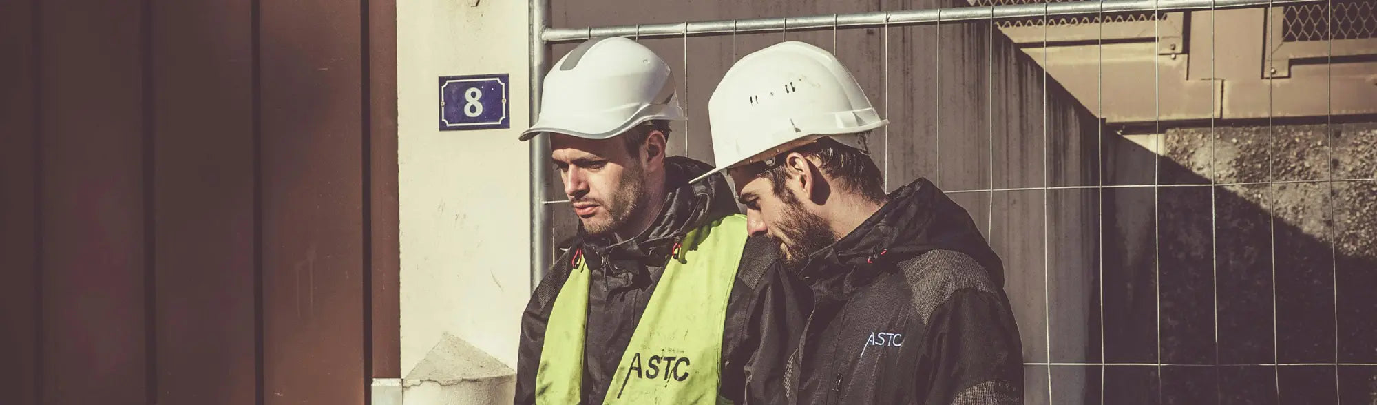 Two construction workers in hard hats showing essential safety gear for traffic cones and safety