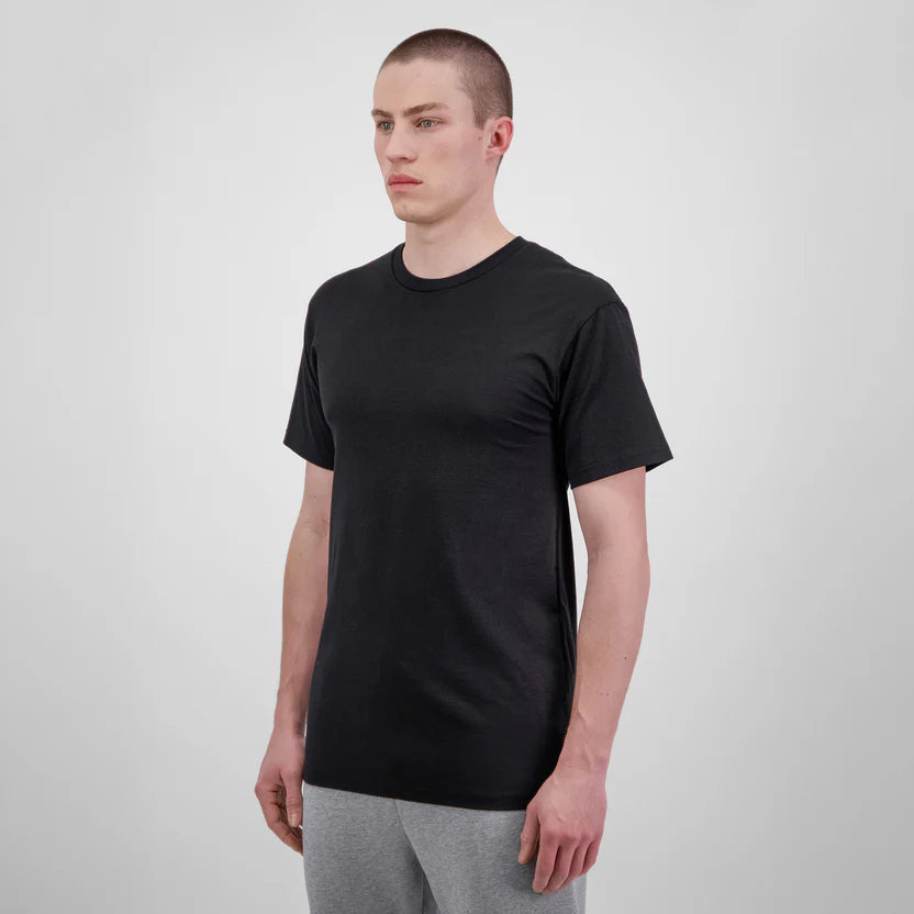 Man wearing a black t-shirt and gray pants on a white background