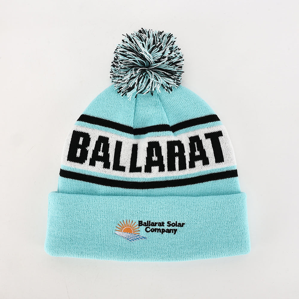 A light blue knitted pompom beanie with ballarat striped band perfect for workwear and uniforms