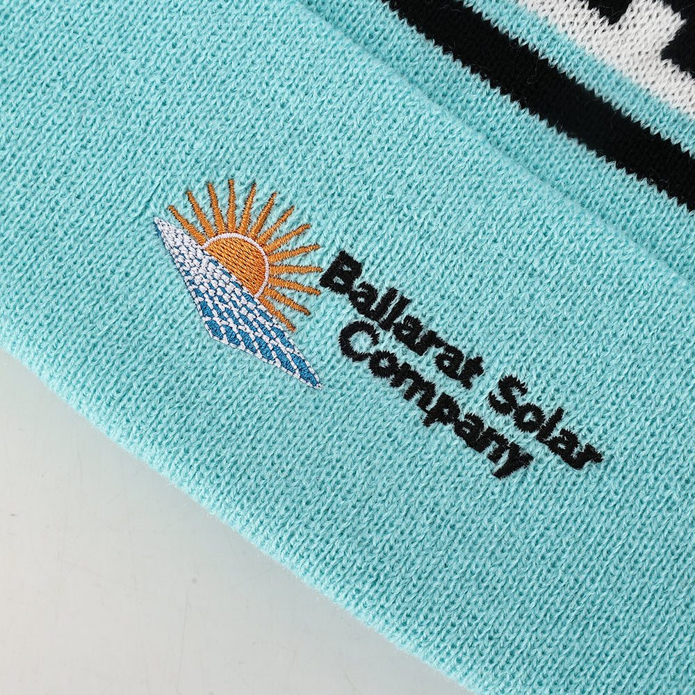 Turquoise knitted pompom beanie with embroidered sun and waves logo perfect for workwear and uniforms