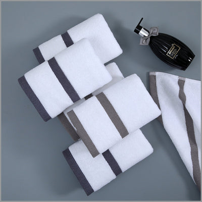 Set of white towels with gray stripes on a gray background