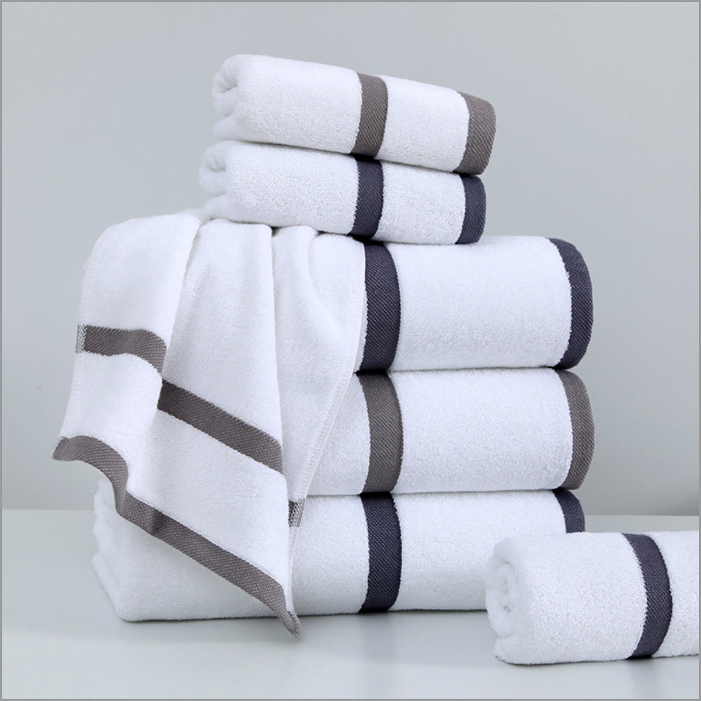Stack of white towels with gray stripes on a light gray background