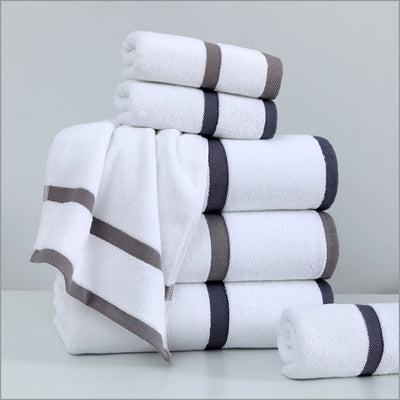 Stack of white towels with gray stripes on a light gray background