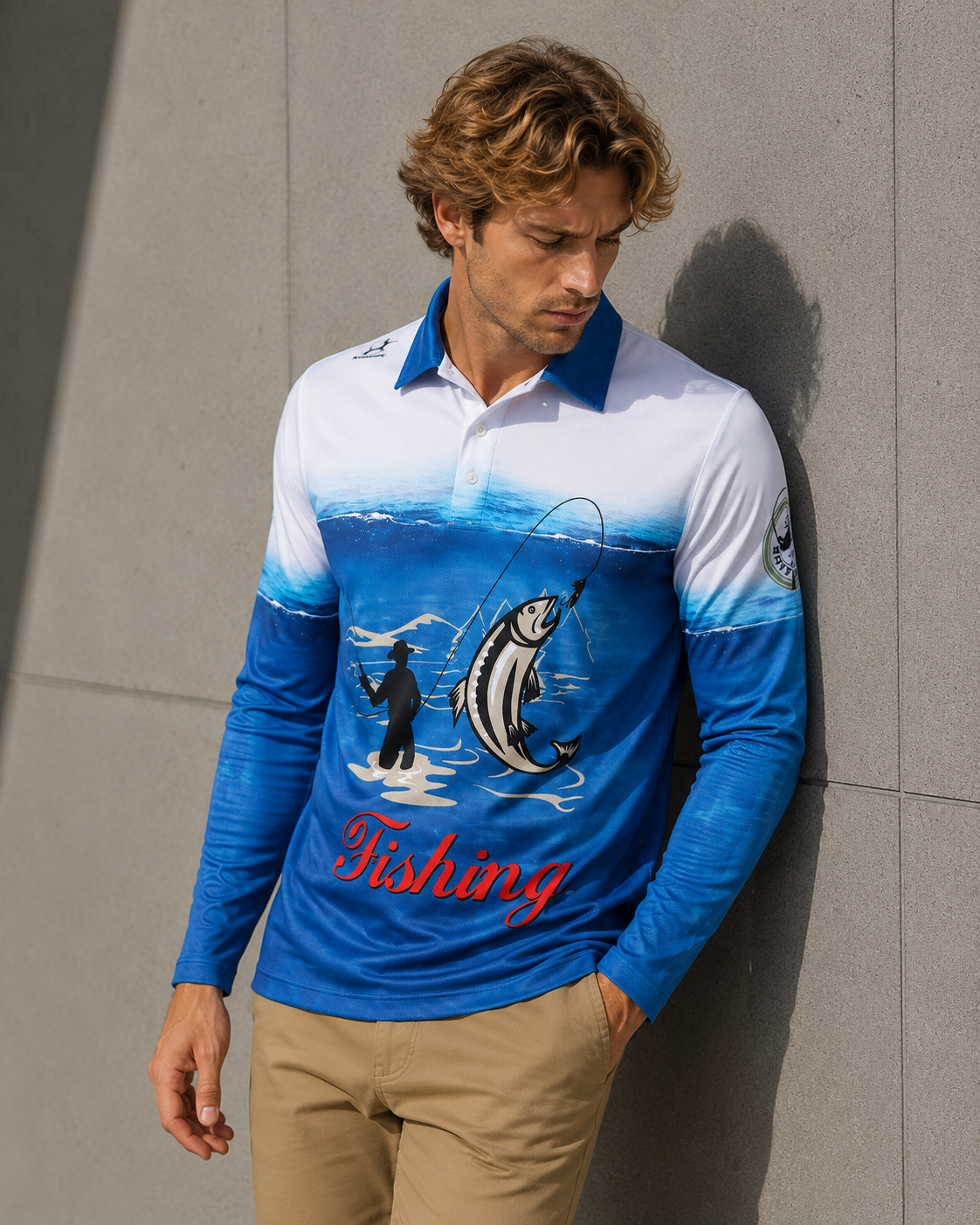 Man wearing a blue and white fishing-themed long-sleeve shirt against a gray wall.