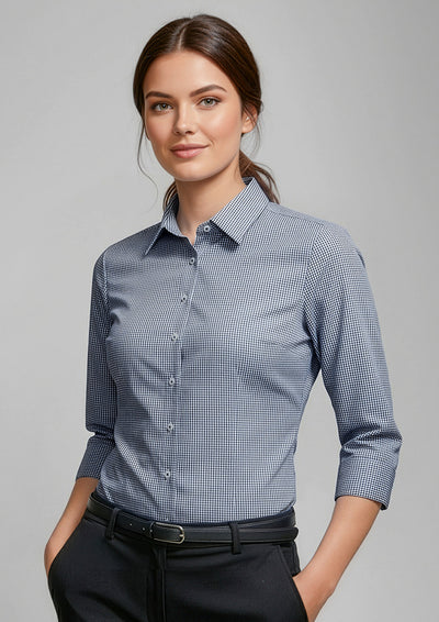 Woman wearing a blue checkered shirt against a gray background