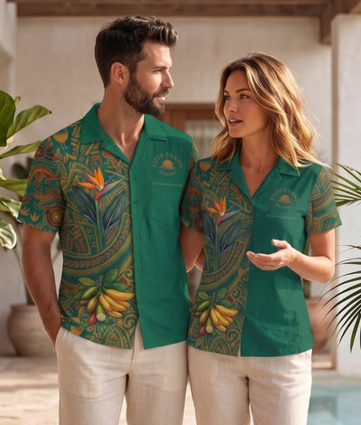 A man and a woman wearing matching green short-sleeve button-up shirts with a tropical print of bananas, birds, and floral motifs, standing in a sunlit outdoor patio setting.