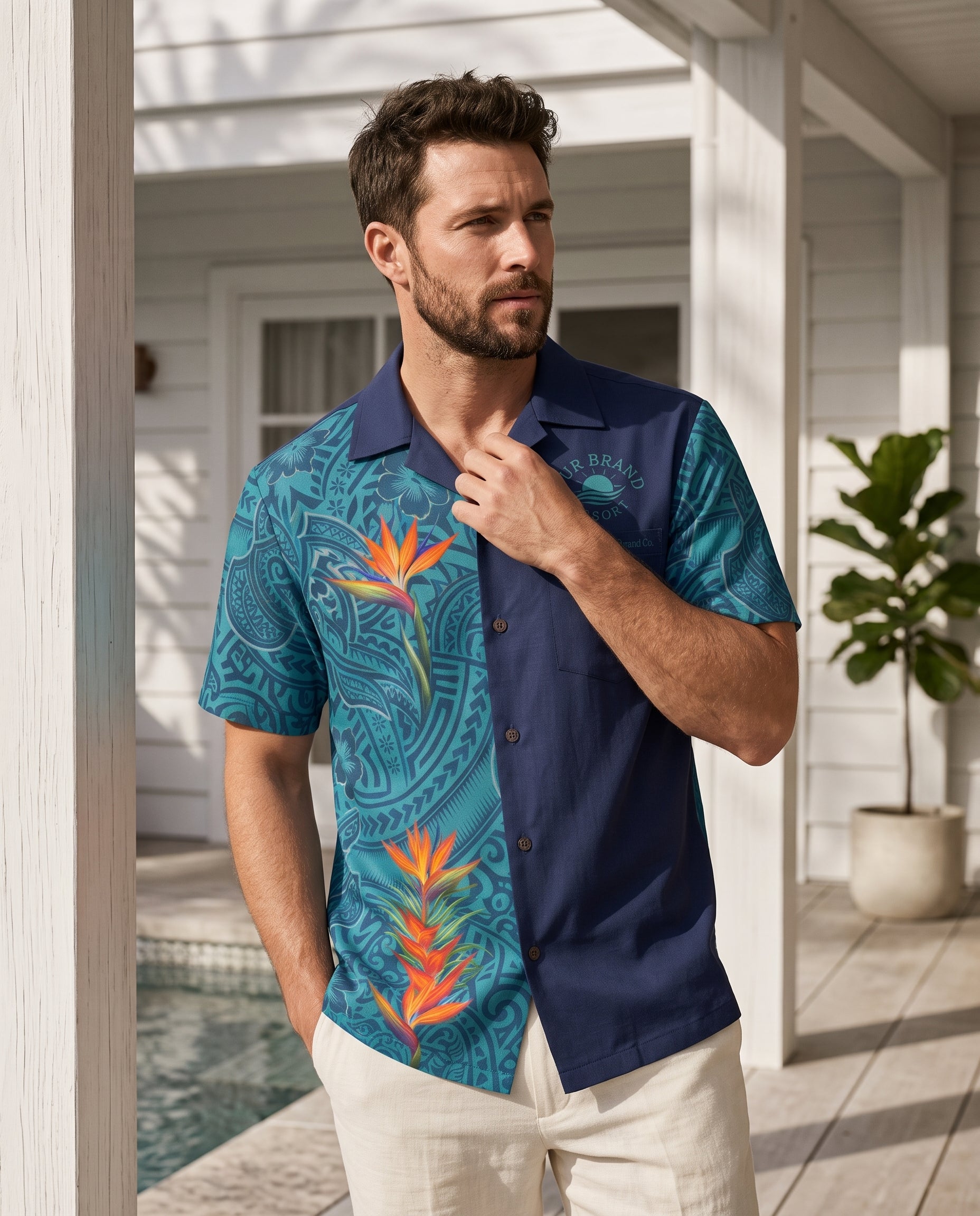 A man wearing a short-sleeve button-up shirt with a split design: one side is navy blue, and the other side features a teal and turquoise tropical floral print with orange bird-of-paradise flowers. The shirt has 'The Beach Club' branding on the chest.