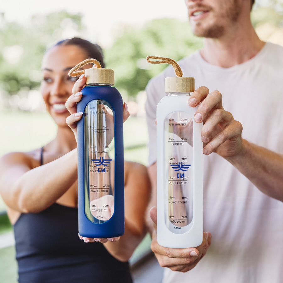 Arlo 1L borosilicate glass water bottles in blue and clear with bamboo lids and measurement markings for work uniforms