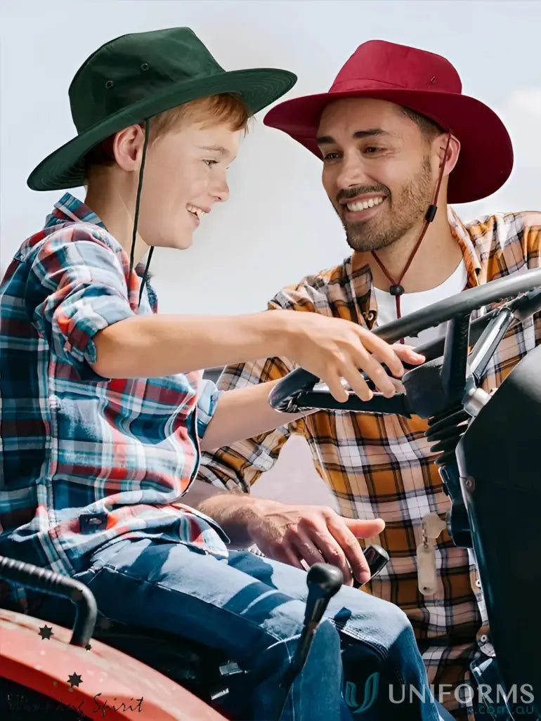 Father and son on tractor wearing hats with winning spirit chin break-away clip safety gear