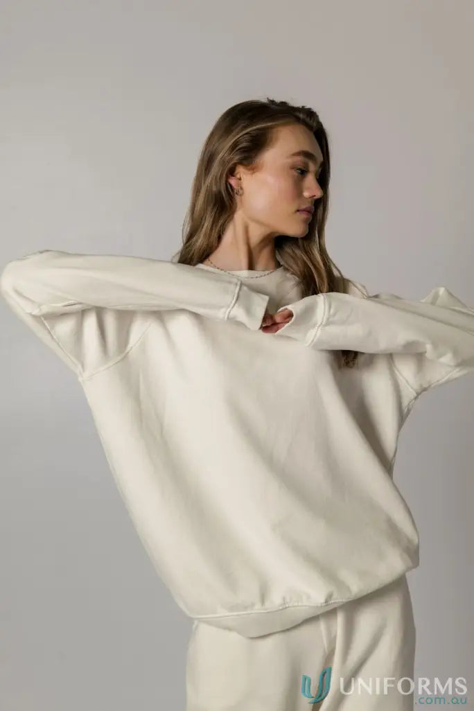 Woman wearing a cozy cream-colored Archie Crew Sweat for a casual look