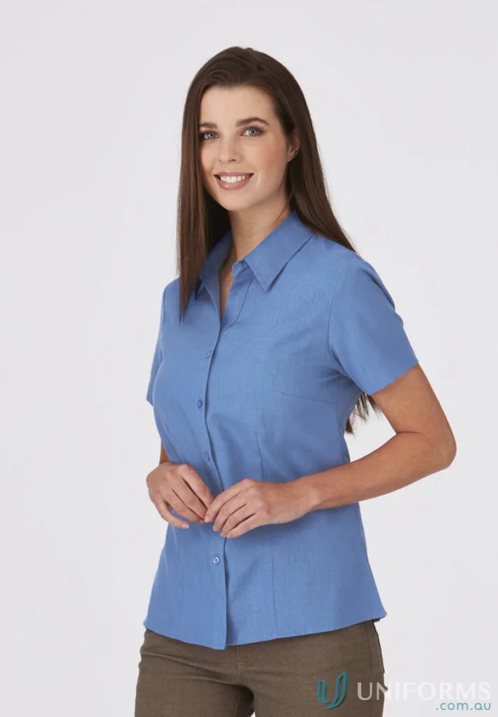 Woman in a blue Ezylin Ladies S/S Shirt, perfect for work uniforms and workwear
