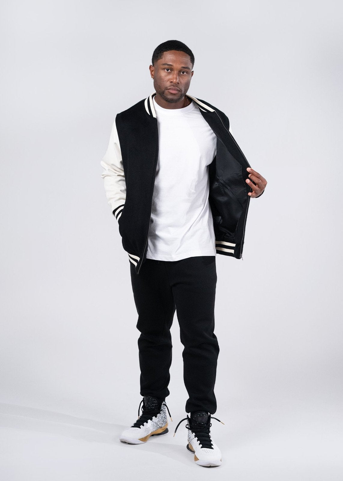 Black and white varsity wool blend jacket with ribbed collar sleeve stripes and zipper front perfect for workwear uniforms
