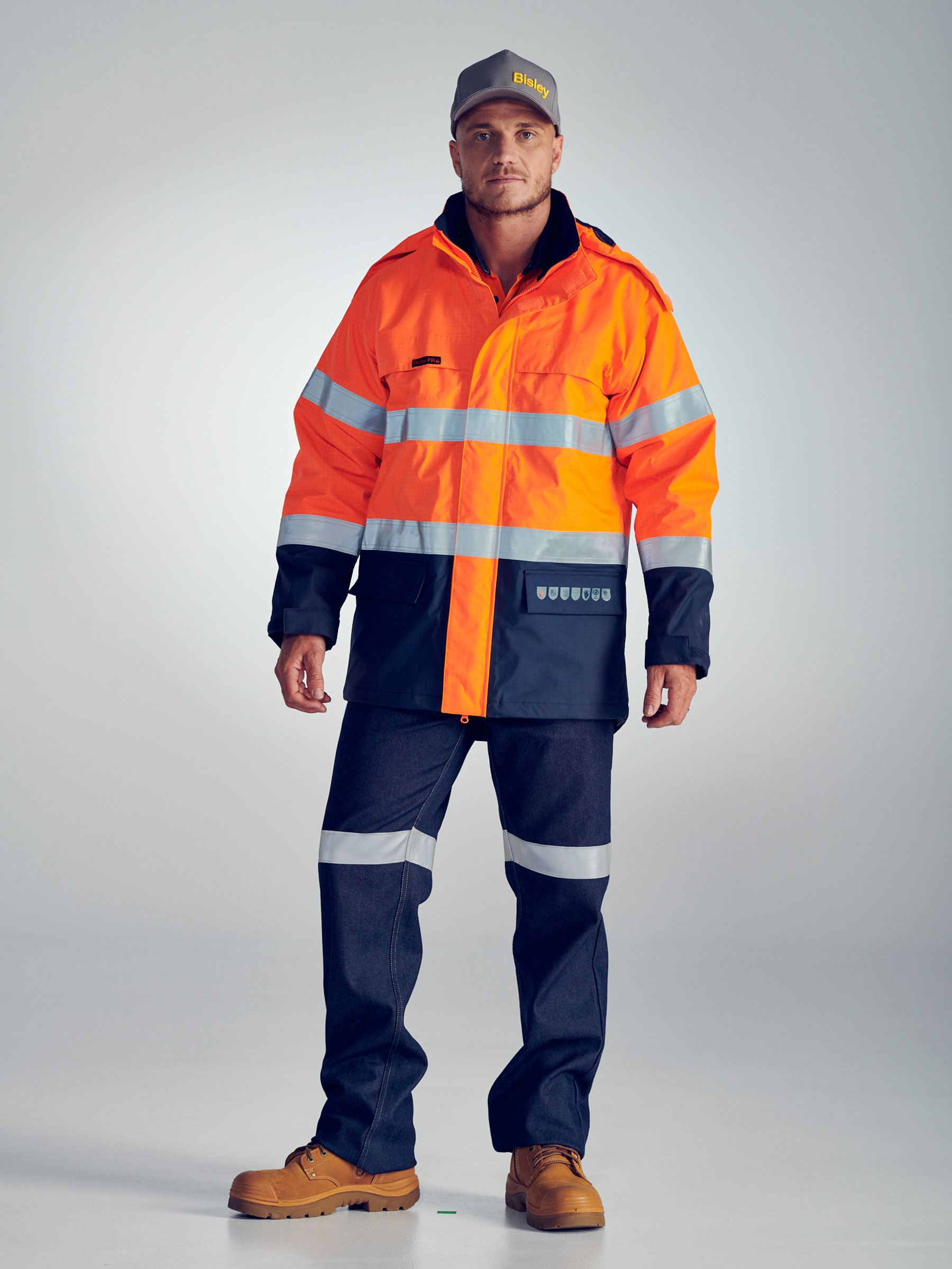 Flame resistant taped wet weather shell jacket in orange/navy with touch tape closure