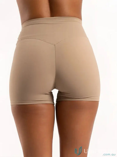 Beige invicible scrunch latte shorts with smooth form-fitting fabric and subtle seams perfect for work uniforms or workwear