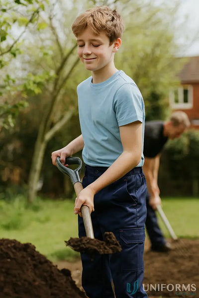 Young boy in kids cotton drill cargo pants holds shovel outdoors