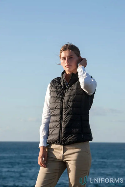 Lady wearing a Ladies Puffer Vest with recycled polyester insulation PolyLoft ® recycled