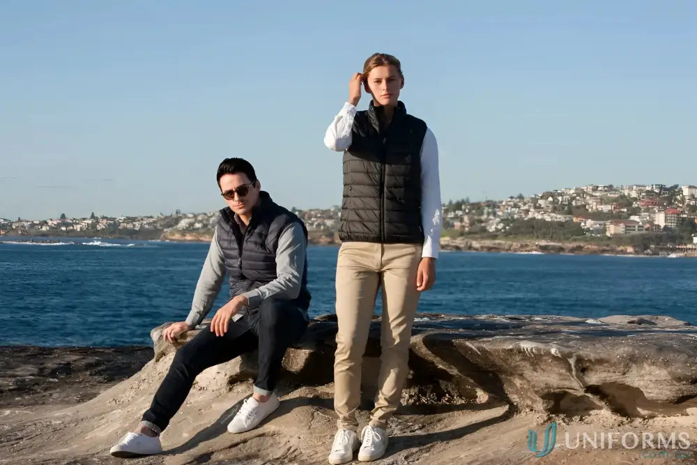 Two people wearing stylish ladies puffer vests with recycled polyester insulation outdoors