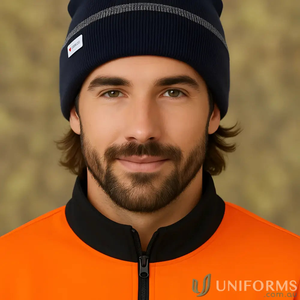 Man wearing navy blue cuff beanie with reflective stripe and orange jacket