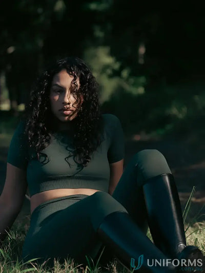 Dark green ribbed crop top and seamless invisible scrunch emerald leggings with black knee-high boots for stylish work uniforms
