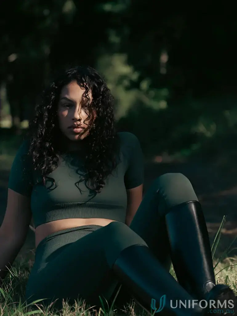 Dark green ribbed crop top and seamless invisible scrunch emerald leggings with black knee-high boots for stylish work uniforms