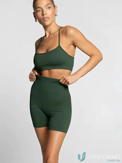 Green seamless athletic set with matching sports bra and biker shorts, likely made of spandex or polyester.