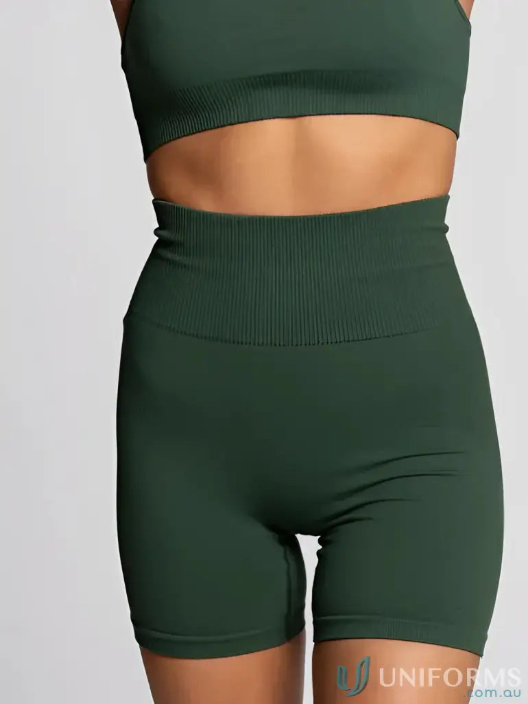 Dark green high-waisted athletic shorts with ribbed waistband and seamless design.