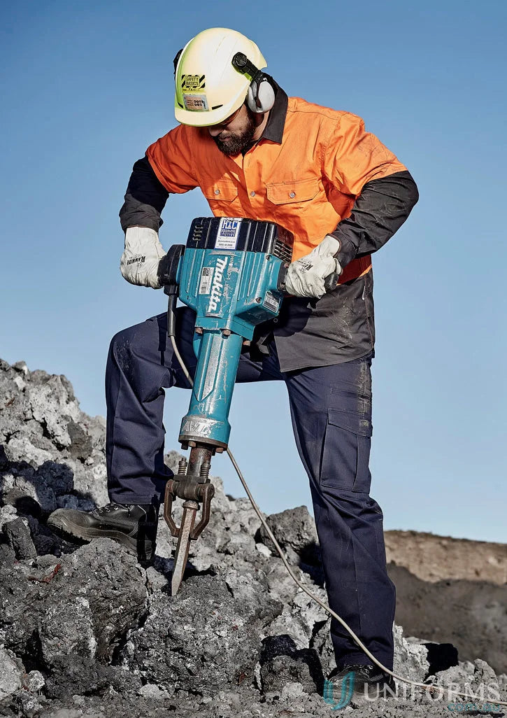 Man using teal jackhammer in Syzmik Mens Cargo Pants ZP501 with reinforced stress points