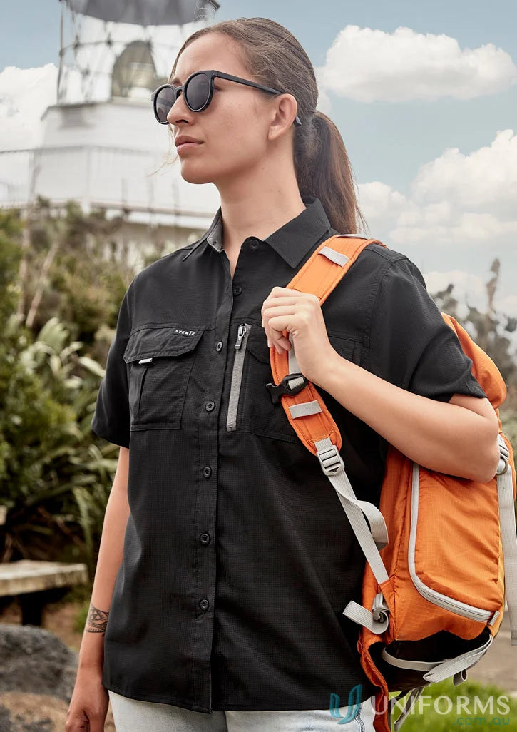 Woman wearing Syzmik Outdoor Ladies SS Shirt with orange backpack, feminine fit outdoor women’s short