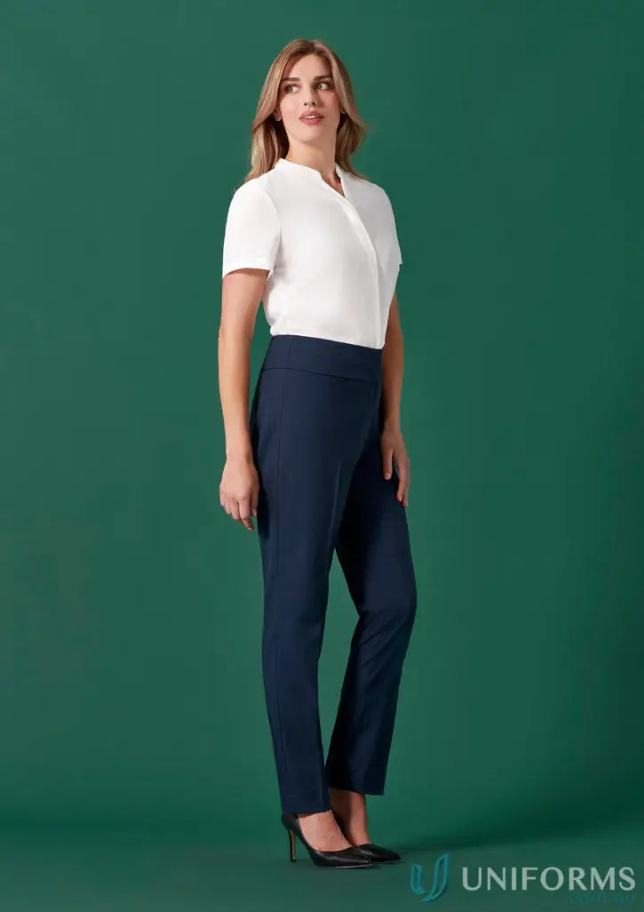 Woman wearing white blouse and dark blue Womens Renew Mid-Waist Slim Leg Pants